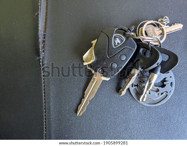 Pahang, Malaysia- 30 January 2021 : Selective focus\
picture of Proton saga keyfob with remote and immobilizer with\
background of motorcycles\
seat