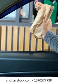 Pahang, Malaysia - January 2021: A Starbucks Staff Giving Take Away Menu In Paper Bag At Drive Thru During Coronavirus Outbreak.