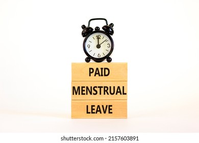 Paid menstrual leave symbol. Concept words Paid menstrual leave on wooden blocks. Black alarm clock. Beautiful white table white background. Business medical paid menstrual leave concept. Copy space.