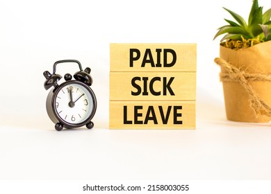 Paid sick leave symbol. Concept words Paid sick leave on wooden blocks. Black alarm clock. Beautiful white table white background. Business medical and paid sick leave concept. Copy space.
