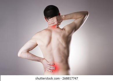 Pain In The Back And Neck In Men On Gray Background. Red Dot