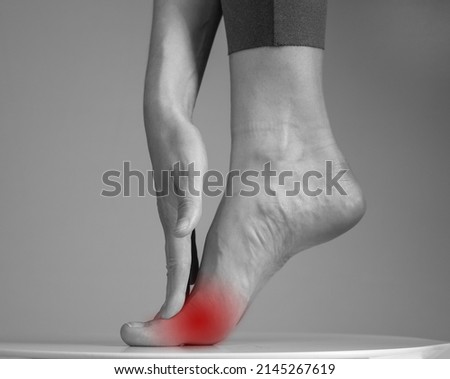 Pain in ball of foot. Woman holding leg with red spot closeup. Ache in metatarsal heads. Intense physical activity, inflammation consequences. Health care and medicine concept. High quality photo