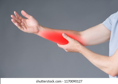 Pain In Forearm, Muscle Inflammation, Studio Shot On Gray Background, Painful Area Highlighted In Red