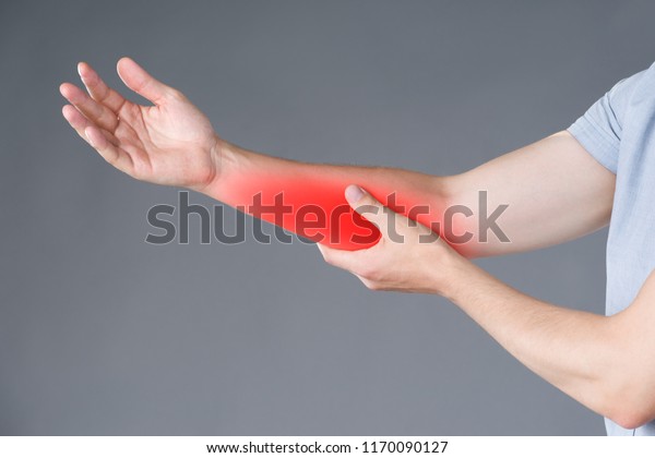 Pain in forearm, muscle\
inflammation, studio shot on gray background, painful area\
highlighted in red