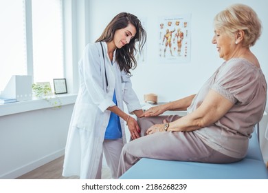 Pain in the knee. Good looking nice aged woman holding her knee and looking at her doctor while explaining where she feels pain. Support for strained muscles. Doctor fixing womans knee with hands - Powered by Shutterstock