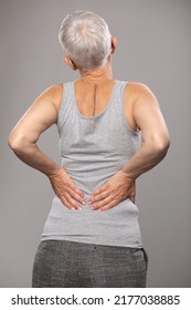 Pain in lower back, backache, sciatica, senior old woman with short gray hair and body and spinal muscle problems
