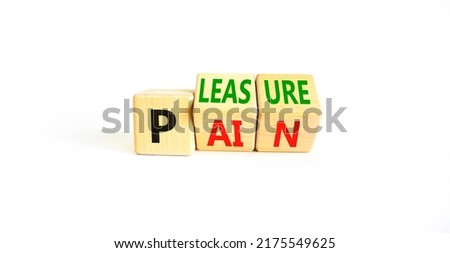 Pain or pleasure symbol. Concept words Pain or Pleasure on wooden cubes. Beautiful white table white background. Business and pain or pleasure concept. Copy space.