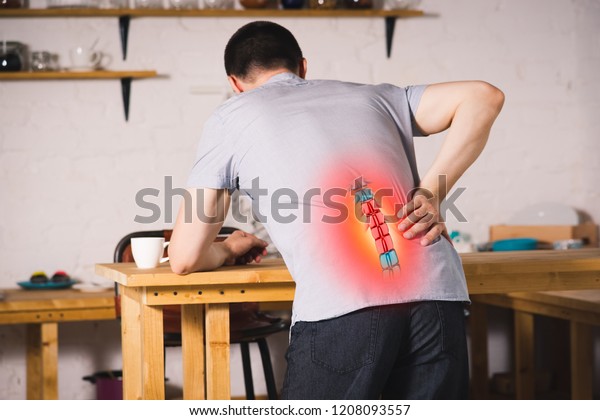 Pain in the spine,\
a man with backache at home, injury in the lower back, photo with\
highlighted skeleton
