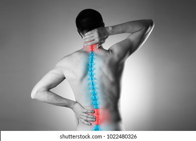 Pain in the spine, a man with backache, injury in the human back and neck, black and white photo with highlighted skeleton - Shutterstock ID 1022480326