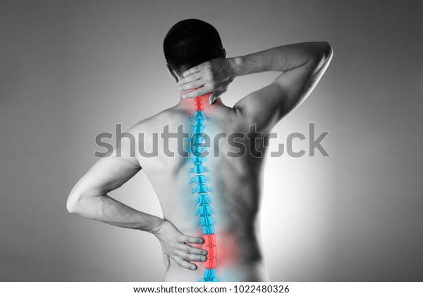 Pain in the spine, a man with backache, injury\
in the human back and neck, black and white photo with highlighted\
skeleton