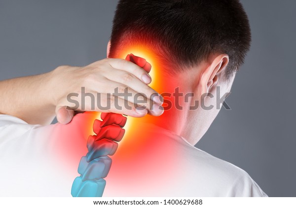 Pain in the spine, a man with backache, injury\
in the human neck, chiropractic treatments concept with highlighted\
skeleton