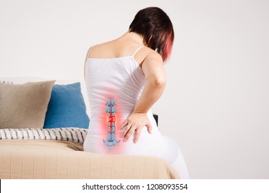 Pain in the spine, woman with backache at home, injury in the lower back, photo with highlighted skeleton - Shutterstock ID 1208093554