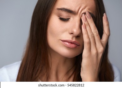 Pain. Tired Exhausted Stressed Woman Suffering From Strong Eye Pain. Portrait Of Beautiful Young Female Feeling Sick, Having Headache, Nose Pain And Touching Painful Eyes. Healthcare. High Resolution