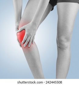 Pain In Woman Knee. Female Holding Hands On Spot Knee Pain.