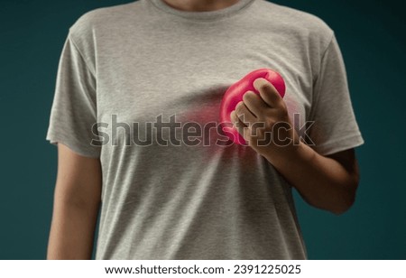 Painful, Heart Attack Concept. Young Adult Woman Squeezed a Red Balloon against her Chest. Heart Disease or feeling very Heartbreak and Sorrow