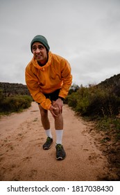 Painful Look On Face Fit Young Male Athlete With Knee Injury During Run On Wet Mountain Path In Cloudy Weather