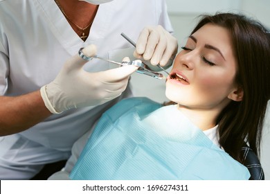 Painkiller anesthesia injection. Dentist examining a patient's teeth in modern dentistry office. Closeup cropped picture with copyspace. Doctor in disposable medical facial mask. - Powered by Shutterstock