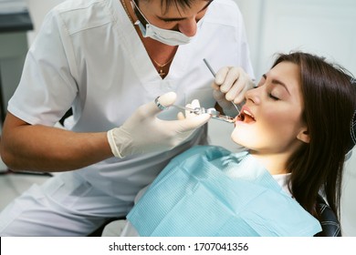 Painkiller anesthesia injection. Dentist examining a patient's teeth in modern dentistry office. Closeup cropped picture with copyspace. Doctor in disposable medical facial mask. - Powered by Shutterstock