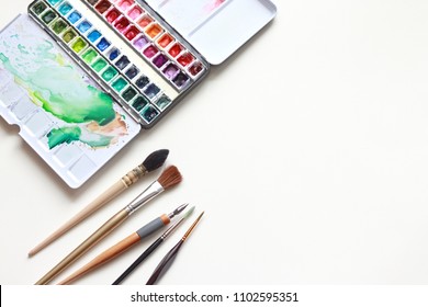 Paint Accessories And Watercolor And Blank Book On Wooden Table. (workplace Mock Up,Copy Space,Isolated, White Copy Space,Color Copy Space, Blank Copy Space, Wood Copy Space, Paint Mock Up.)