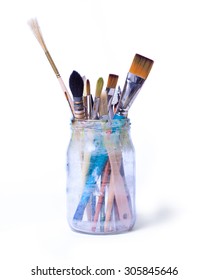 Paint Art Brushes In A Glass Jar Isolated Over White Background.