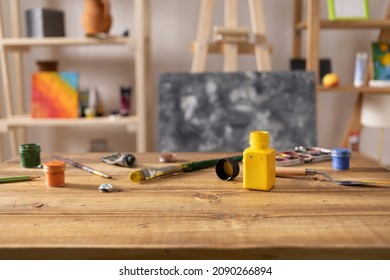 Paint brush and bottle at wood table. Paintbrush and art painter artist tools on desk background texture. Painting supplies in artist studio