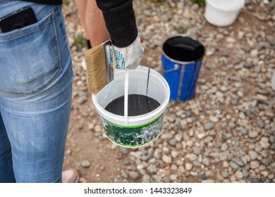 Paint brush. Man paints objects in the yard. Work with color. Master painter. Work for everyone. Handyman