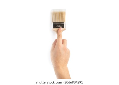 A paint brush in a man's hand. Renovation concept. Supplies and tools for painting walls isolated on white
