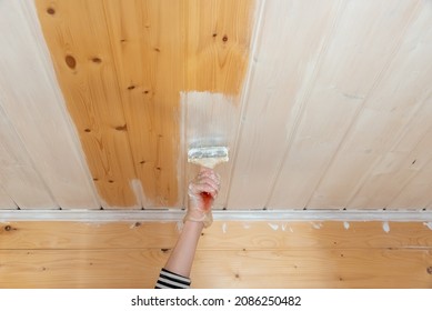 Paint brush on a white, wooden ceiling. Painting streams.