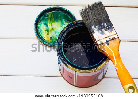 Paint brushes and paint cans on white table. Paint tne wood in blue.