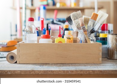 Paint Brushes And Crafting Supplies On The Table In A Workshop.