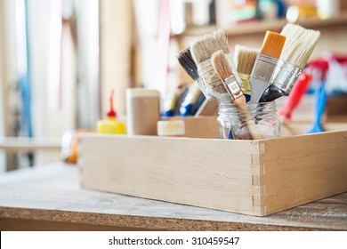 Paint Brushes And Crafting Supplies On The Table In A Workshop.