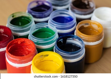Paint brushes and watercolor paints,  tempera paints on the table in a workshop, selective focus, close up, on wooden background. 
Set of gouache - bouquet.  - Shutterstock ID 1618127350
