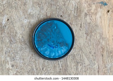 A Paint Can Lid Sits On A Plywood Floor