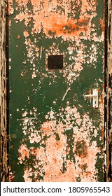 Paint Flakes Off A Closed Door Revealing Layers Of Red And Green