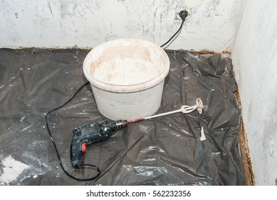 Paint Mixer And Paint Bucket On Covered Floor 