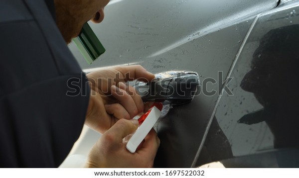Paint protection film installation on side panel\
surface of luxury sports car. PPF is polyurethane film applied to\
painted of car to protect the paint from stone chips, bug splatter,\
and abrasion