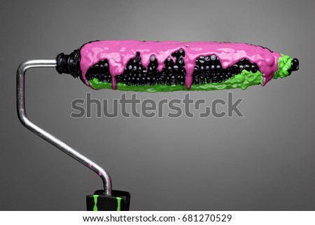 Paint Roller black corn with pouring green toxic and purple paint on gray background. Fashion food concept.Creative advertising of paint