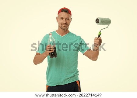 Paint roller for decorator. Renovation work. Decorator man do renovation painting. Man renovator isolated on white. Renovating painter at break. Home renovator. Man painter hold painting roller