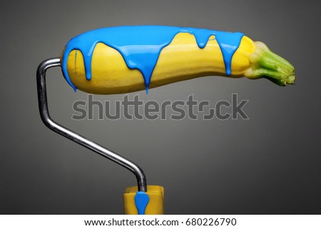 Paint Roller eggplant with smashing yellow and purple paint on gray background. Fashion food concept.Creative advertising of paint