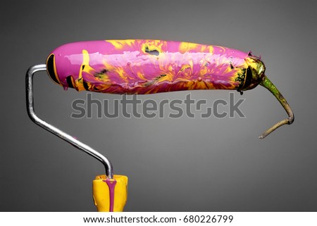 Paint Roller eggplant with smashing yellow and purple paint on gray background. Fashion food concept.Creative advertising of paint