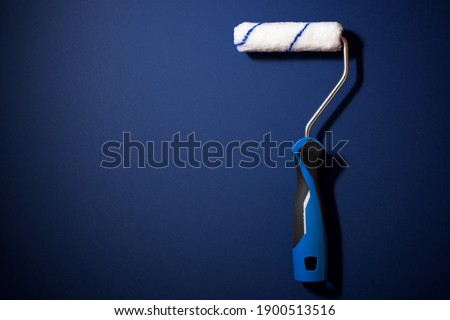 Paint roller on a blue table.
