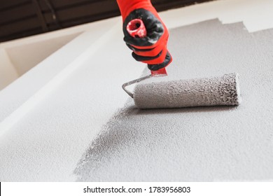 Paint roller on the wall during painting - renovation of the building facade in dark gray - Shutterstock ID 1783956803
