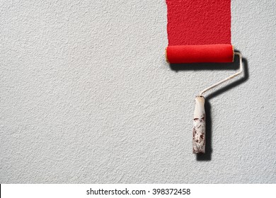 Paint Roller Painting With Red Paint On White Wall With Rough Texture