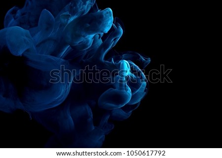 paint stream in water, red colored ink cloud, abstract background on a black,process of dissolution in water of a blue acrylic paint