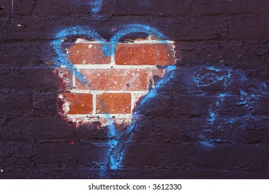 Paint That Has Peeled To Reveal The Brick With A Blue Spray Painted Tag In The Shape Of A Heart