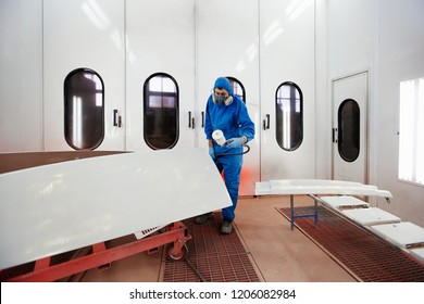 Paint And Varnish Camera. The Worker Paints A Detail. Production Of Fiberglass Details Of The Boat And Car