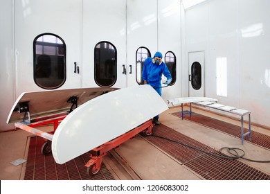 Paint And Varnish Camera. The Worker Paints A Detail. Production Of Fiberglass Details Of The Boat And Car