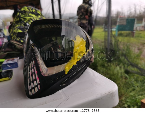 Paintball mask hit with\
yellow paint ball