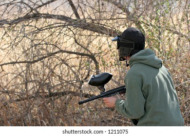 Paintball - Teen With Paintball Gun And Face Mask Looking Out For The Enemy