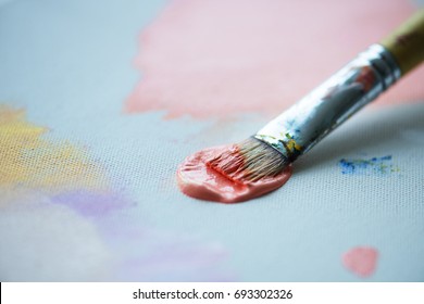 Paintbrush with color on a canvas painting